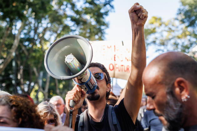 October 24, 2026, Lisbon, Portugal: A protester with a raised fist, holds a megaphone at the front line during the demonstration. People march through central Lisbon during a demonstration demanding affordable housing and protesting against the rising cost of living. The protest started at Marques de Pombal and ended at Rossio Square, where demonstrators set up tents at the end of the march in protest against Portugal s housing crisis. Lisbon Portugal - ZUMAs197 20261024_aaa_s197_593 Copyright: xHenriquexCasinhasx